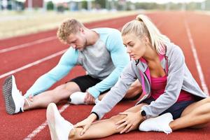 Man and woman racing on outdoor track photo