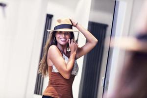 Beautiful woman thinking what to dress in walk-in closet photo