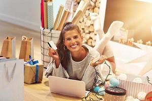 Adult woman at home wrapping Christmas presents photo