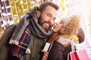 pareja adulta de compras en la ciudad durante la época navideña foto