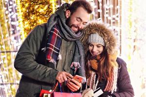 pareja adulta de compras en la ciudad durante la época navideña foto