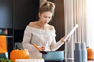 mujer adulta en la cocina preparando platos de calabaza para halloween