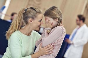 Little girl is crying while with her mother at a doctor on consultation photo