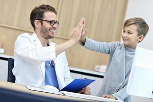 Little boy in clinic having a checkup with pediatrician photo