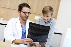 Little boy in clinic having a checkup with pediatrician photo