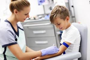 Brave little boy having blood collection for tests photo