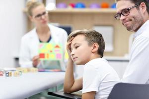 Child psychologist working with family in office photo