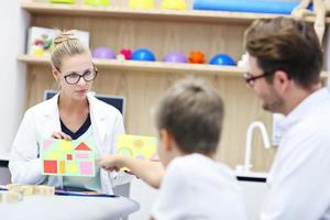 Child psychologist working with family in office photo