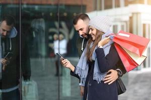 Portrait of happy couple with shopping bags after shopping in city photo