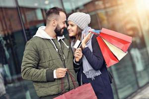 retrato de pareja feliz con bolsas de compras después de ir de compras en la ciudad foto