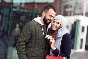Portrait of happy couple with shopping bags after shopping in city photo