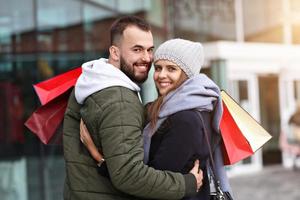 Portrait of happy couple with shopping bags after shopping in city photo