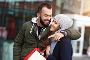 Portrait of happy couple with shopping bags after shopping in city photo