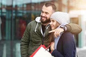 Portrait of happy couple with shopping bags after shopping in city photo