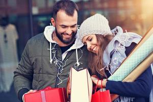 Portrait of happy couple with shopping bags after shopping in city photo