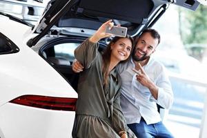 Adult couple choosing new car in showroom photo