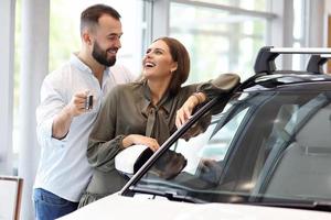 Adult couple choosing new car in showroom photo