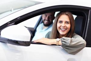 Adult couple choosing new car in showroom photo