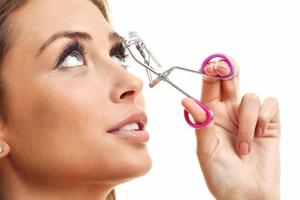 Picture showing woman using eyelash curler over white photo