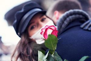 Happy couple celebrating Valentines Day in masks during covid-19 pandemic photo