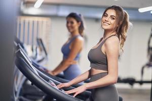 Two girl friends working out on treadmill photo