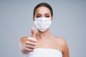 Portrait of beautiful woman in mask on gray background photo