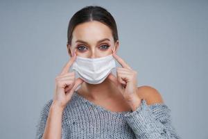 Portrait of beautiful woman in mask on gray background photo