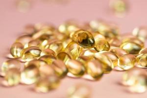 D3 K2 capsules on a pink background. Healthy life concept. photo