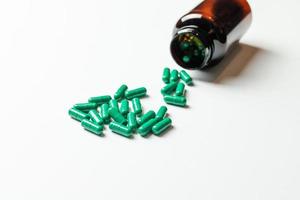 Green pills with packaging on a white background. photo