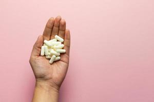 Zinc tablets in the hand on a pink background. photo