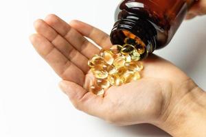 Vitamin D3 capsules poured out of the package. Care for health and immunity. A woman's hand. photo