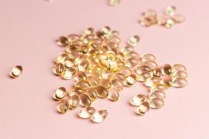 D3 K2 capsules on a pink background. Healthy life concept. photo