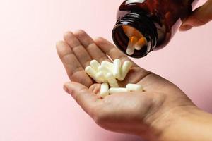 Zinc tablets in the hand on a pink background. photo