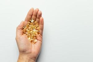 Vitamin D3 capsules on the hands. White background, space for text. photo