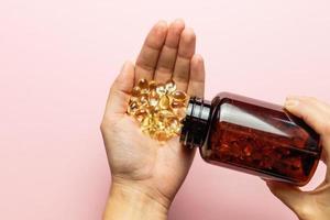 Vitamin D3 capsules poured out of the package. Care for health and immunity. A woman's hand. photo