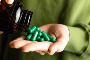 Caffeine capsules on woman's hands. The concept of arousal and energy. photo