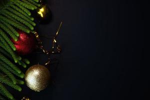 Christmas decorations with spheres gifts and pine needles with space for text and black background photo