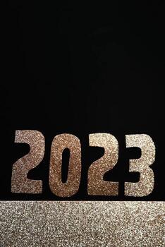 Happy New Year 2023. Golden numbers on a black background with glitter photo
