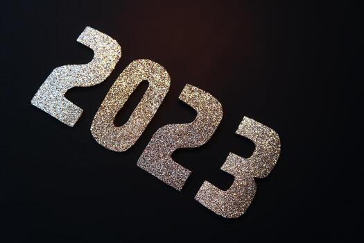Happy New Year 2023. Golden numbers on a black background with glitter photo