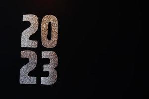 Happy New Year 2023. Golden numbers on a black background with glitter photo