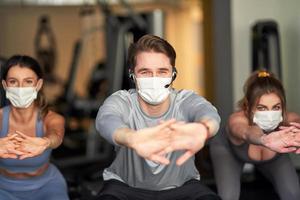 Group of people wearing masks working out in a gym photo