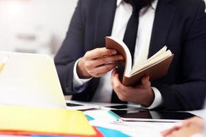 Midsection of businessman searching through his agenda photo