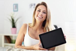 Happy woman with tablet on sofa photo