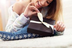 Woman lying on carpet with present photo