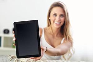 Happy woman with tablet on sofa photo