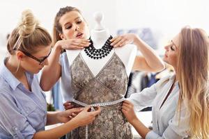 Team of women working on mannequin in atelier photo