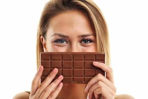 Portrait of beautiful woman holding chocolate bar photo