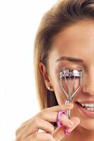 Picture showing woman using eyelash curler over white photo