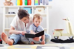 Happy mother playing with baby boy at home photo