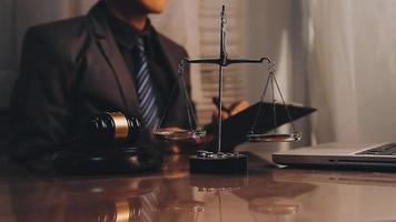 justice and law concept.Male judge in a courtroom on wooden table and Counselor or Male lawyer working in office. Legal law, advice and justice concept. video